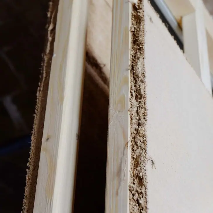 Canto de una placa de arcilla atornillada a un montante de madera en una obra de reforma