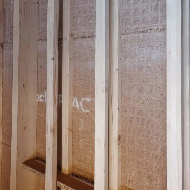 Placas de arcilla con malla de yute colocadas entre montantes de madera en una obra