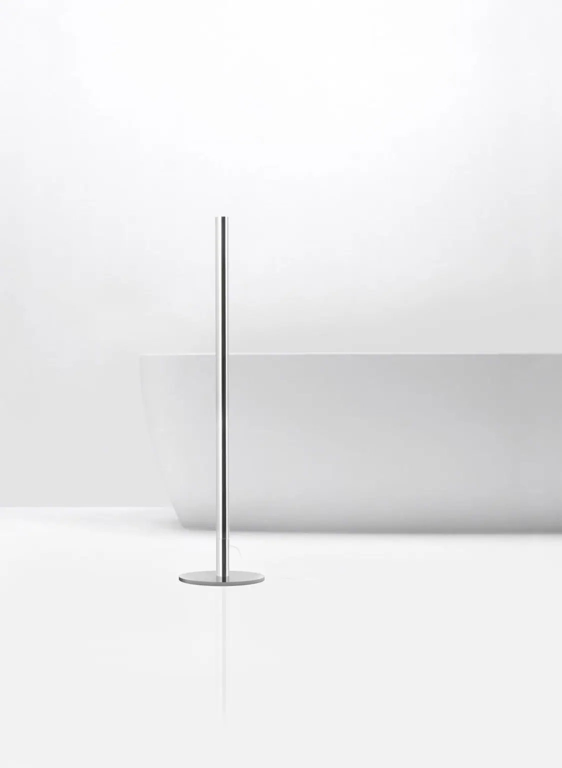 Toallero eléctrico Skinny de un solo tubo cromado, de pie junto a una bañera blanca