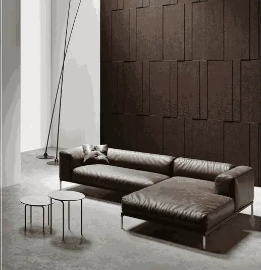 Salón con sofá de piel oscuro ante una pared revestida de placas de corcho Bebop de distintos espesores