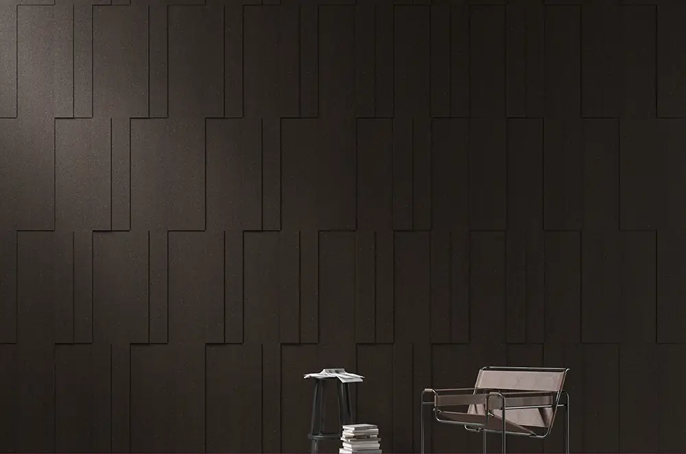 Pared de placas de corcho oscuro Bebop dispuestas en franjas verticales escalonadas, con una butaca