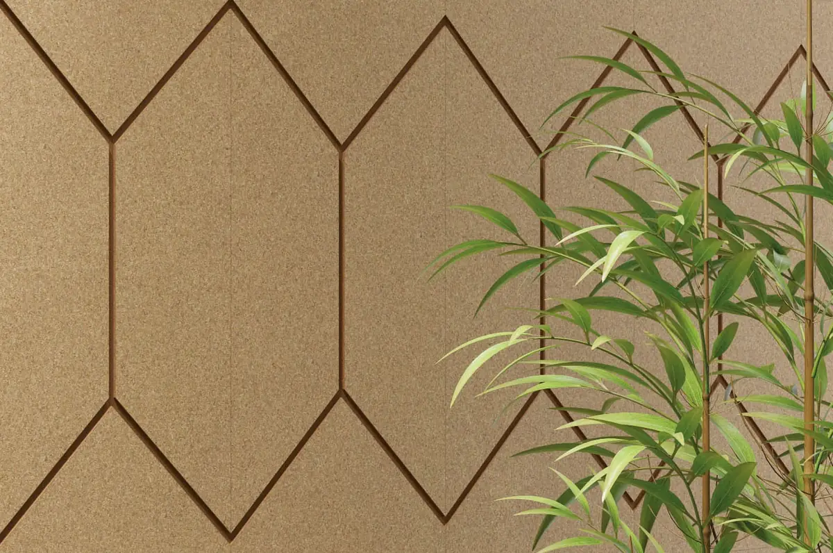 Pared de corcho natural con ranuras de color terracota que dibujan hexágonos alargados, junto a una planta