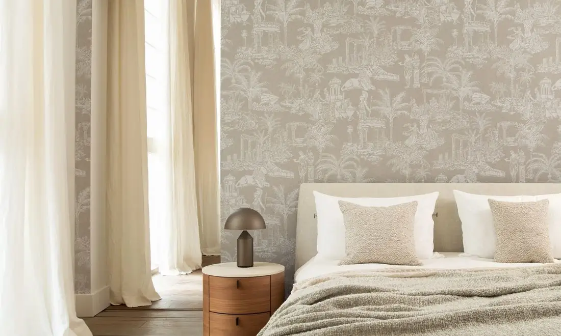 Dormitorio con una pared de papel pintado gris claro con templos, palmeras y figuras clásicas dibujados en blanco