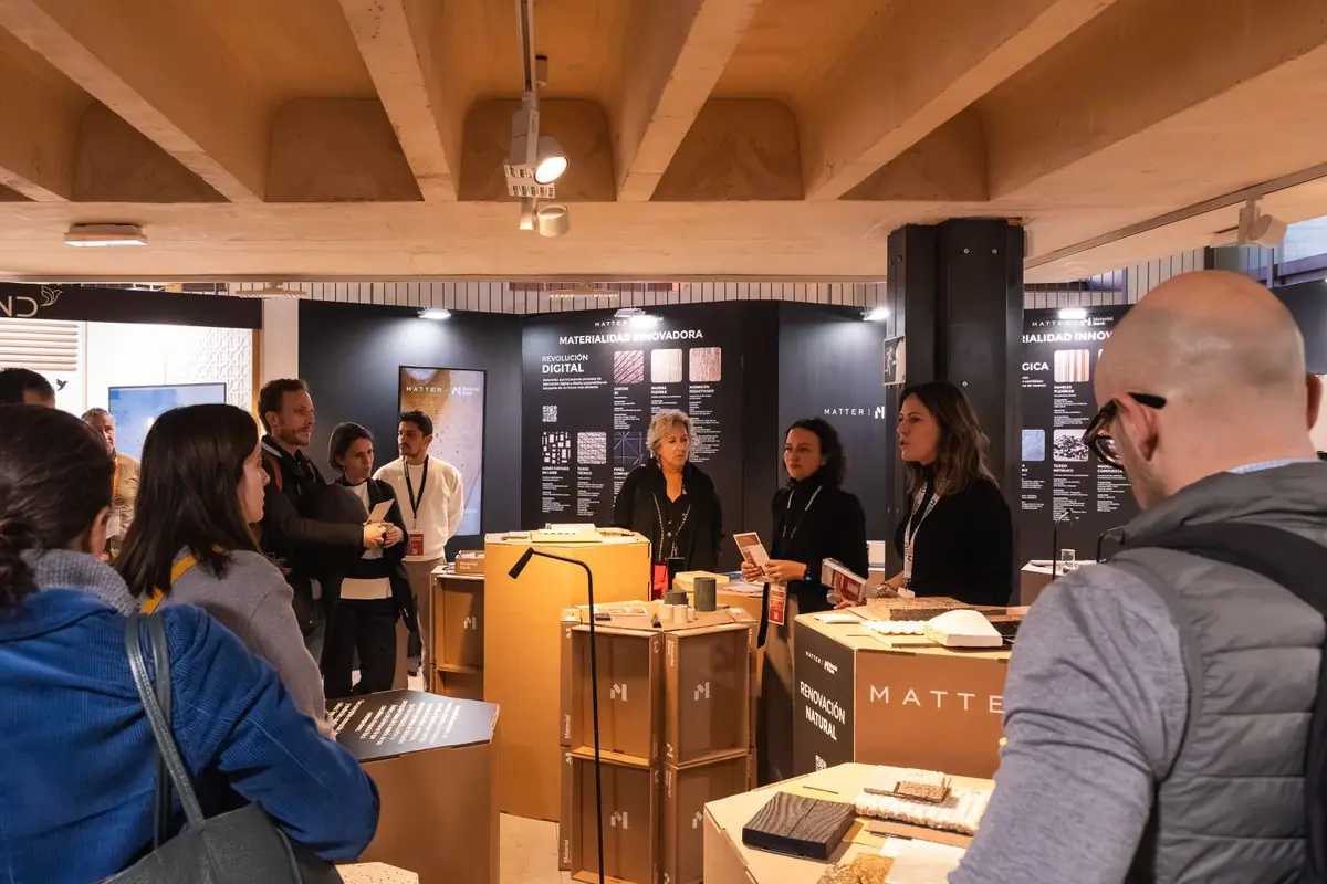 Grupo de visitantes escucha a tres guías de Matter ante el panel Revolución digital