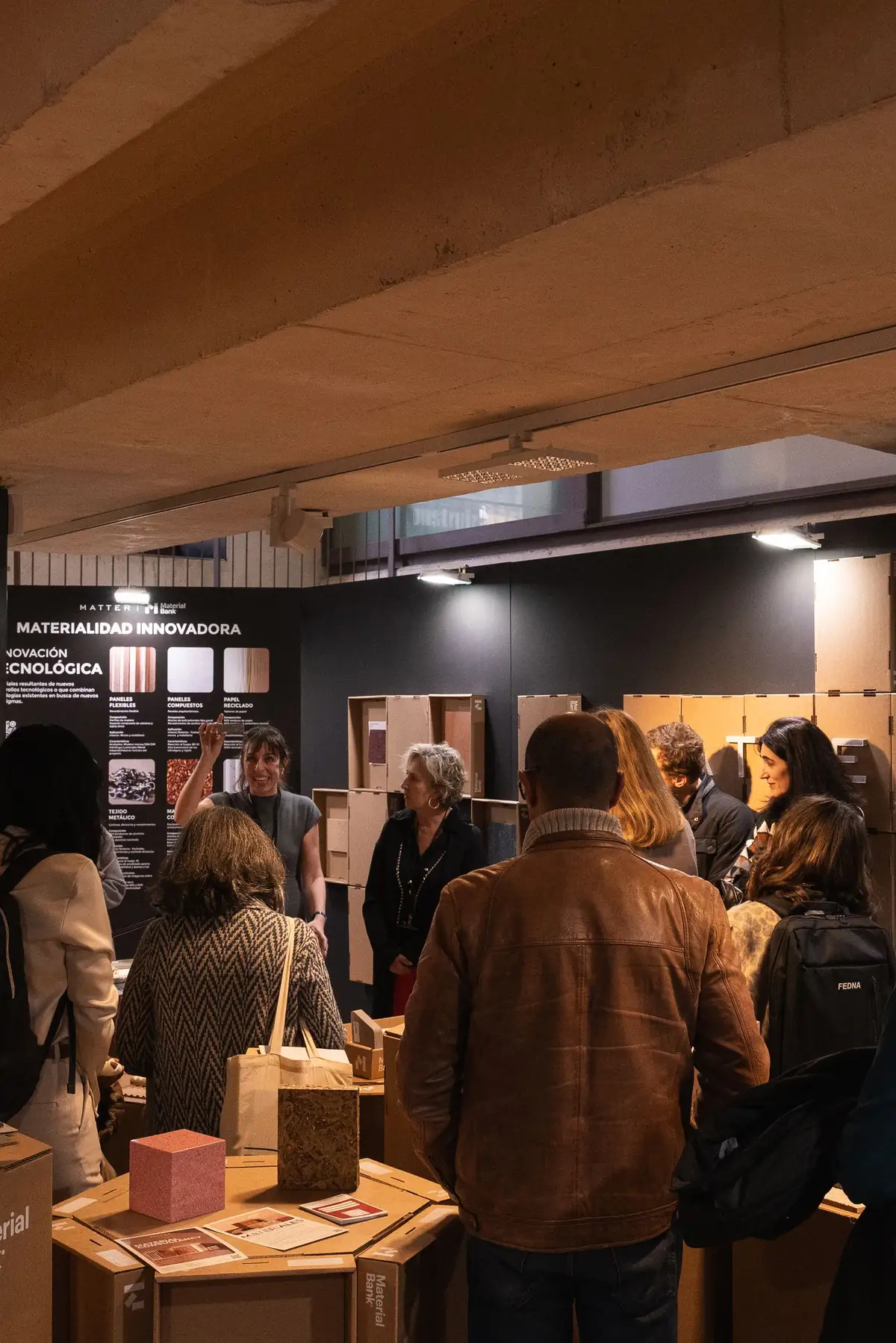 Una guía señala el panel Innovación tecnológica ante un grupo de visitantes