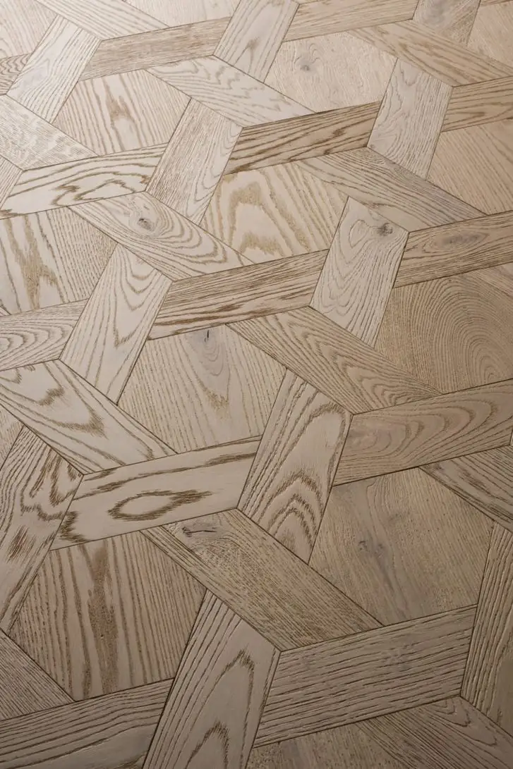 Vista cenital de un pavimento de madera clara en formato Casablanca, con piezas geométricas que forman un damero