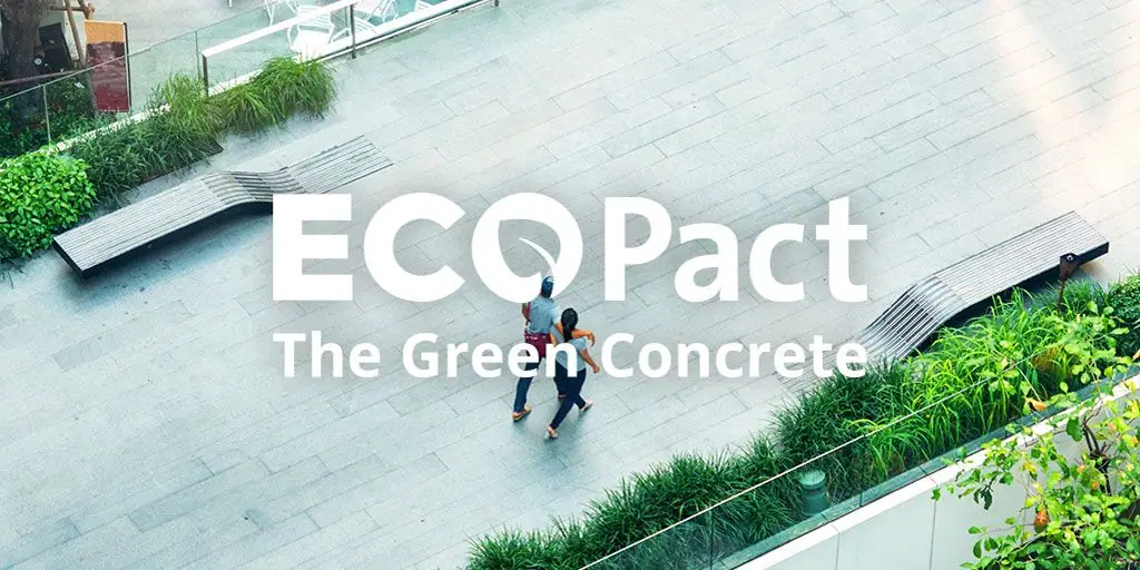 Vista aérea de un paseo peatonal pavimentado, con bancos y jardineras, y el rótulo ECOPact The Green Concrete