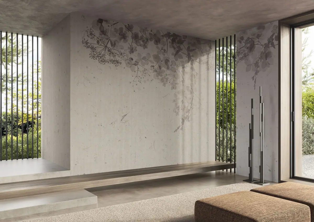 Estancia de hormigón con banco corrido de madera y una pared con ramas de hortensias y umbelas en gris que caen desde lo alto.
