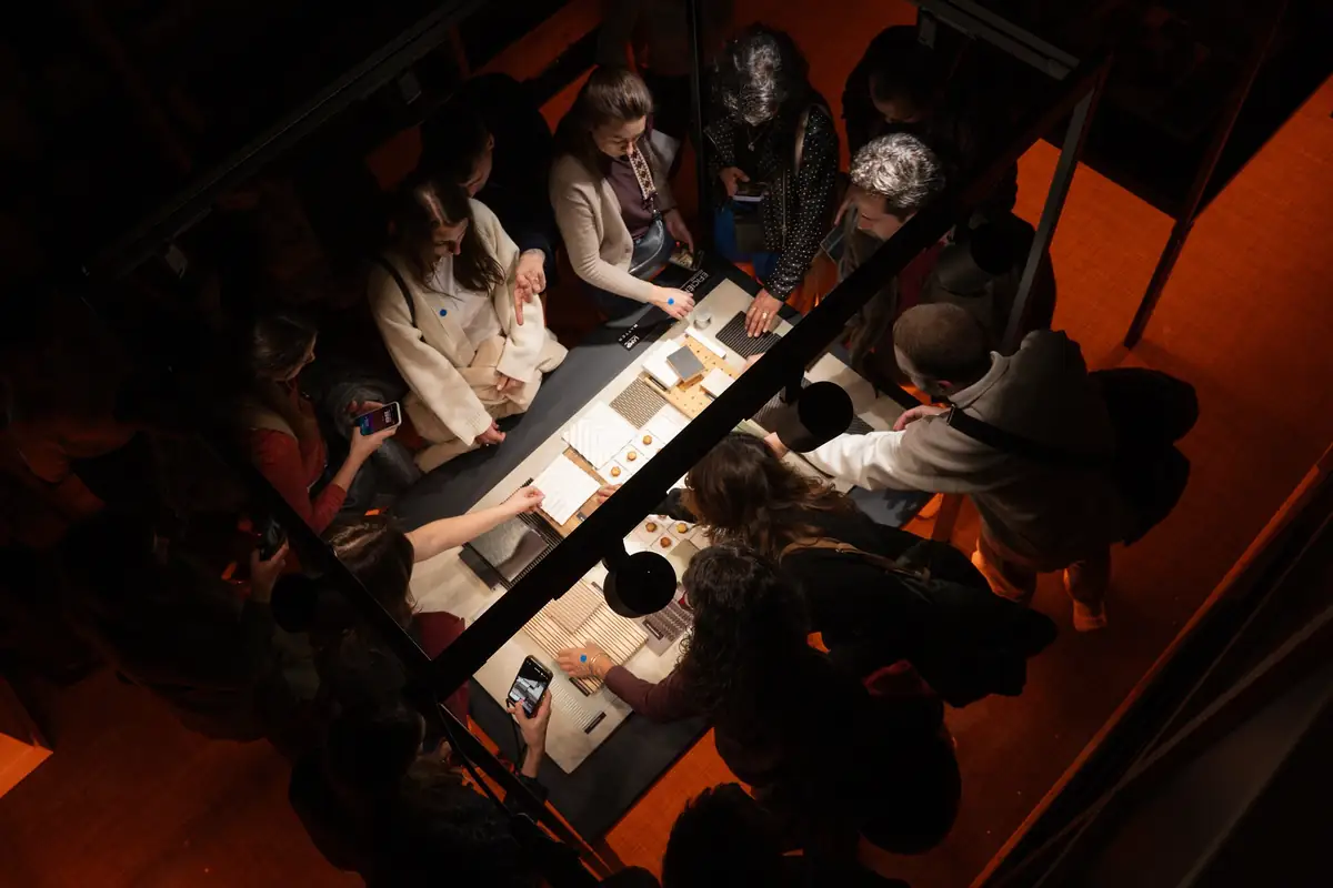 Vista desde arriba de asistentes manipulando muestras de materiales sobre una mesa