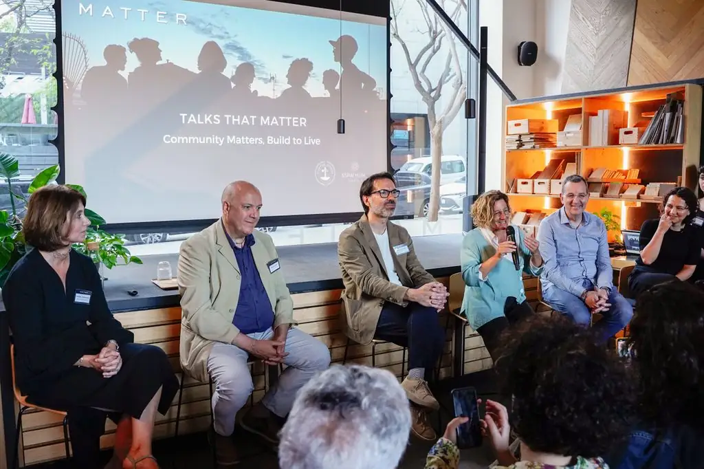 Ponentes sentados ante la proyección de Talks That Matter: Community Matters, Build to Live
