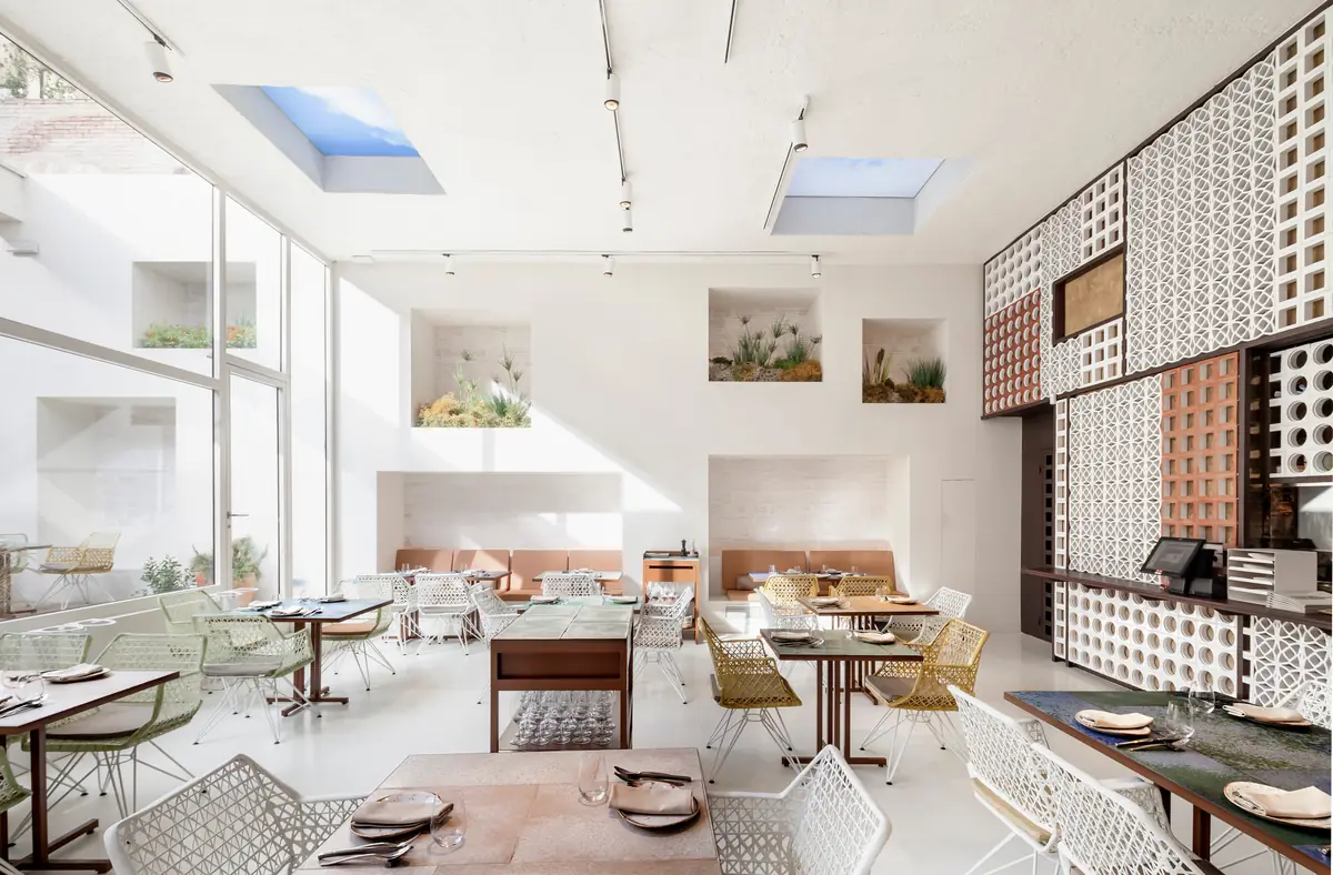 Comedor blanco de Disfrutar con lucernarios, hornacinas con plantas y una pared de celosías cerámicas