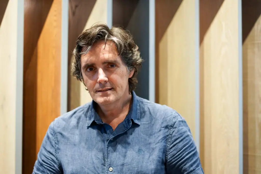 Retrato de Xavier Martí Galí en el showroom de Matter, ante un fondo de lamas de madera