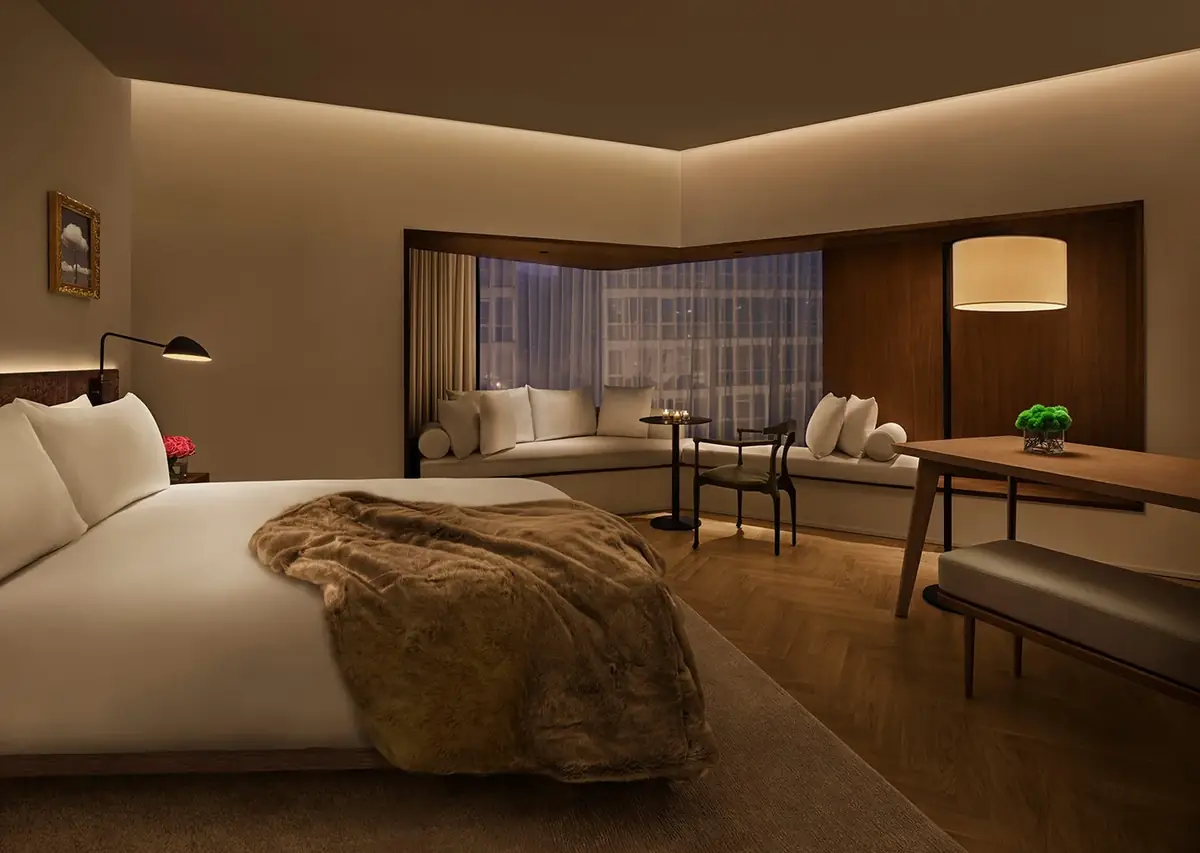 Suite con paredes claras, paneles de madera, parquet y un banco corrido junto a la ventana