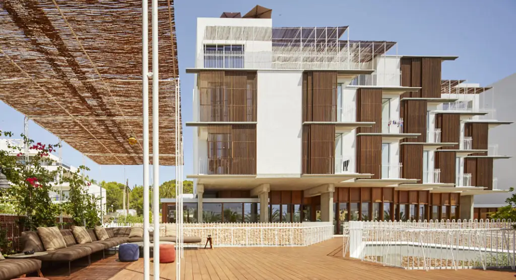Fachada del hotel OD Talamanca con celosías de madera y terraza con pérgola de cañizo