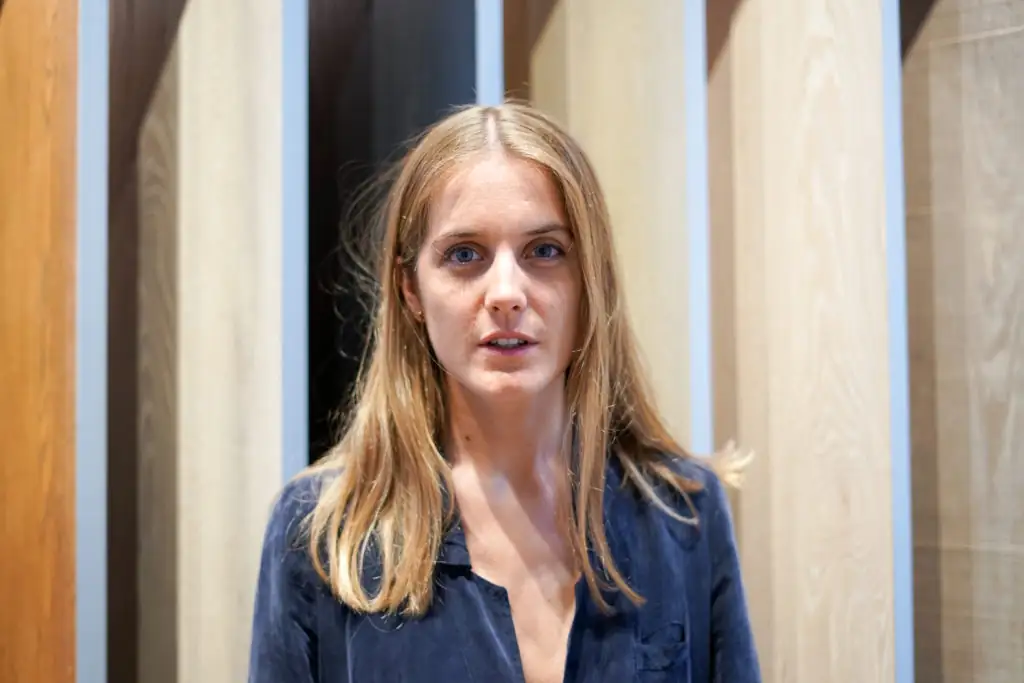 Retrato de Andrea Navarro en el showroom de Matter, ante un fondo de lamas de madera