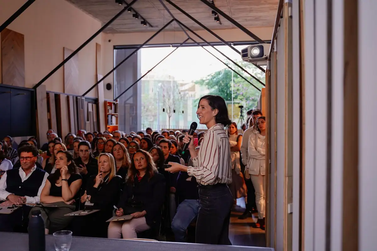 Lucía Millet habla con micrófono ante el público que llena la sala