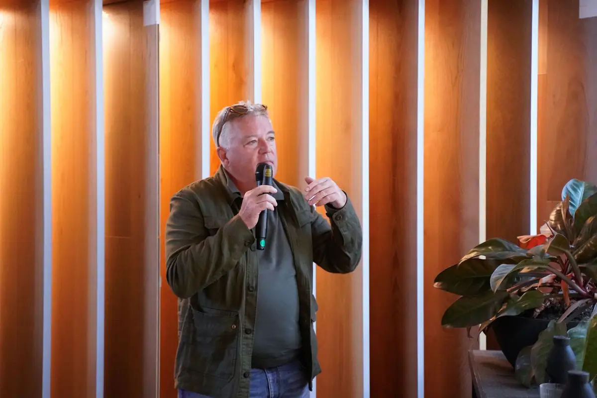 Xavier Claramunt habla con micrófono ante un revestimiento de lamas de madera