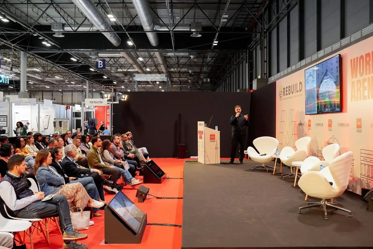 Un ponente habla desde el atril del Workshop Arena con el público a un lado