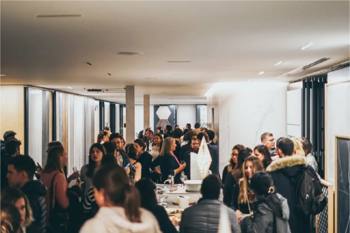 Asistentes conversando de pie en el aperitivo final, entre las mesas y los paneles de muestras de Matter Barcelona