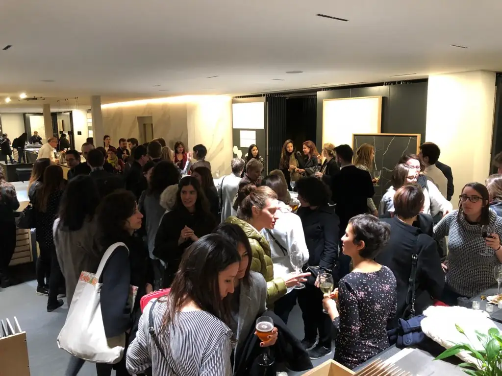 Asistentes conversando de pie en el showroom de Matter tras la charla