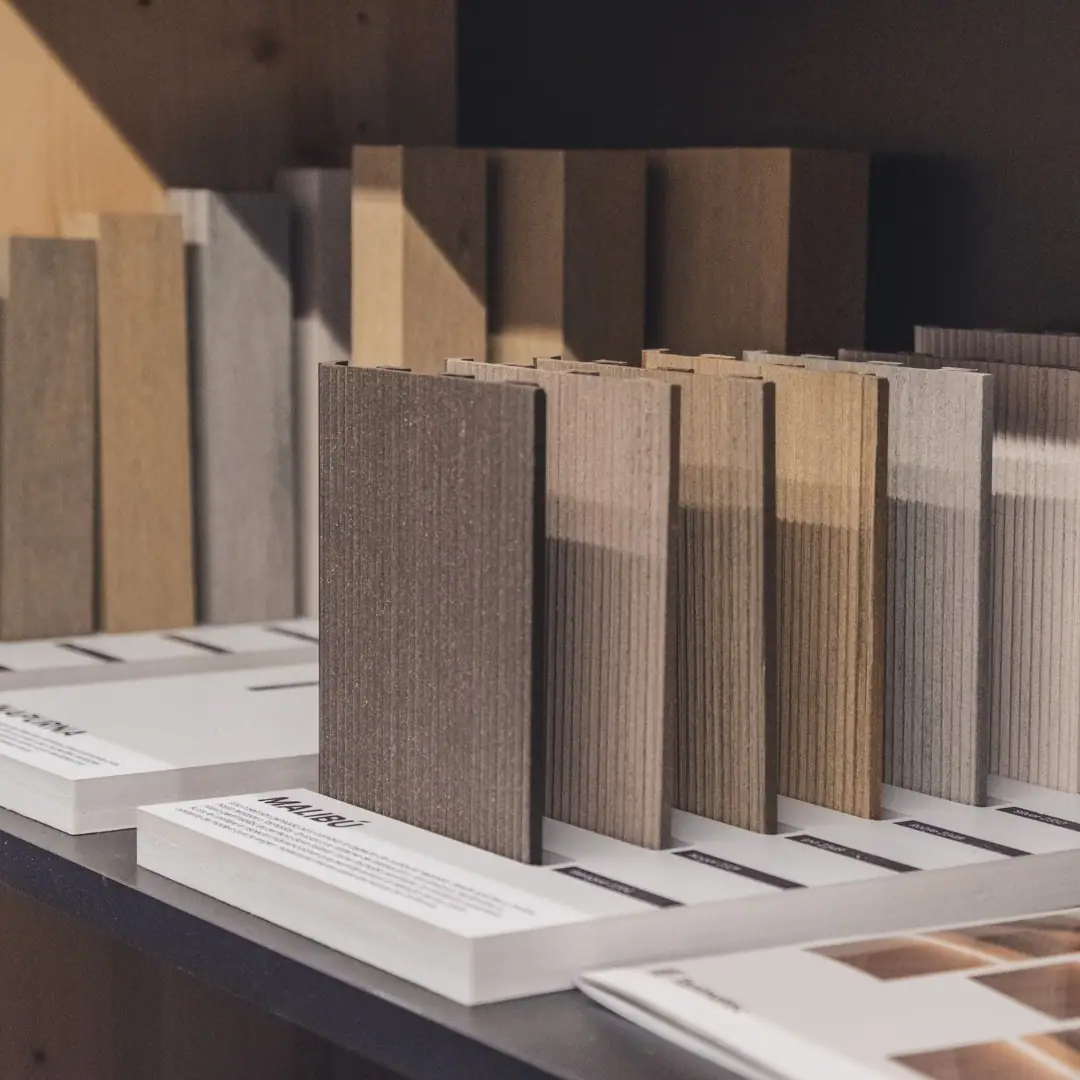 Muestras de perfiles en distintos tonos de gris, beige y marrón expuestas en una estantería
