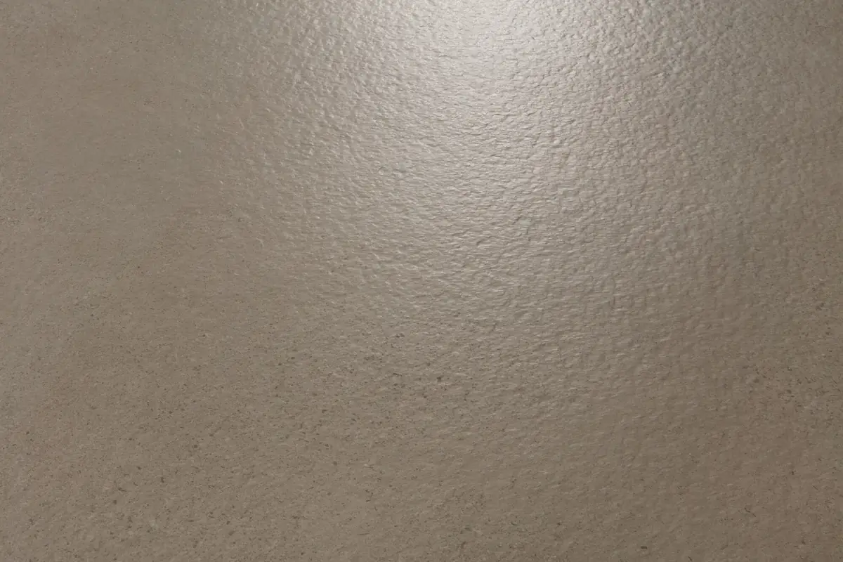 Detalle a contraluz de la superficie rugosa de una baldosa porcelánica efecto cemento