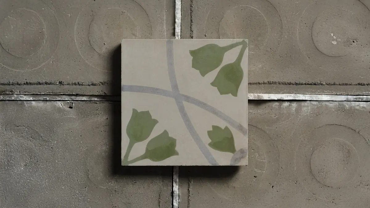 Cementina decorada con flores verdes y líneas grises curvas sobre un fondo de cemento