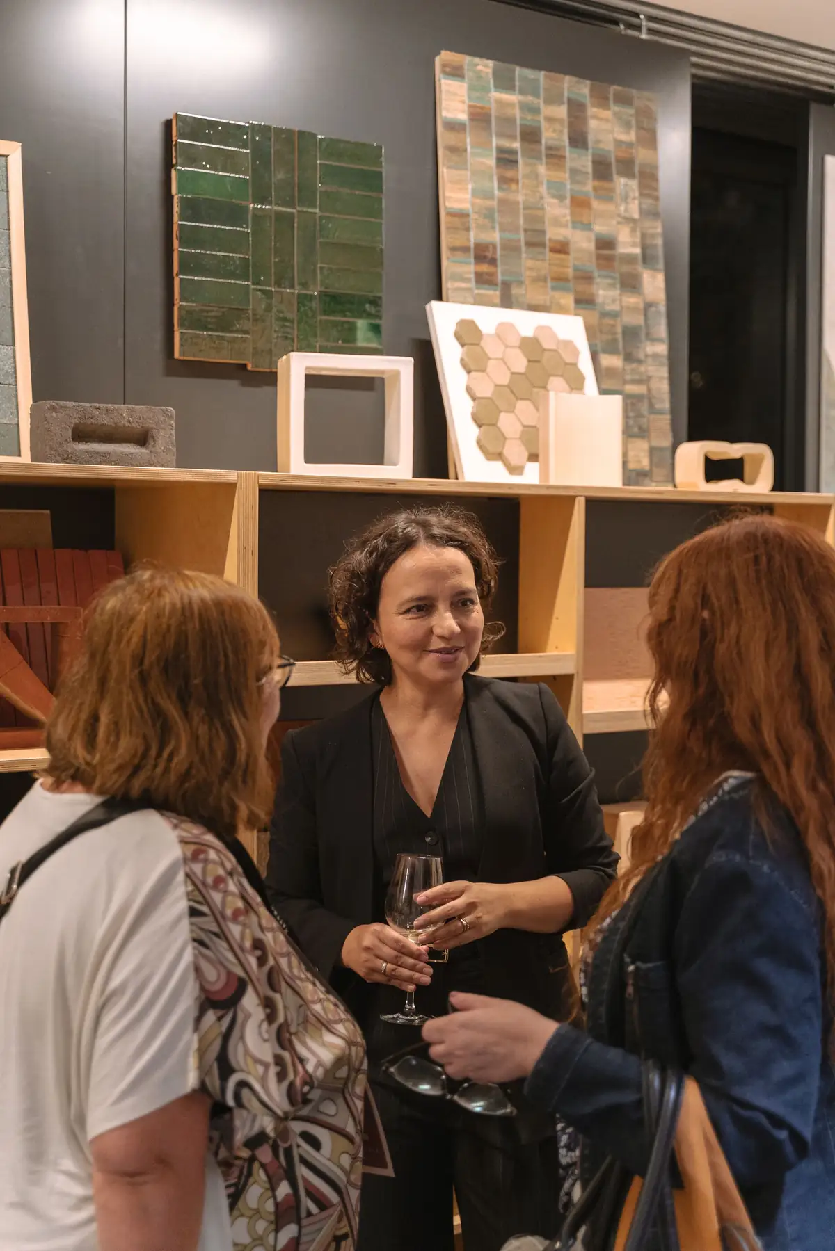 Invitadas conversando ante muestras de revestimientos cerámicos