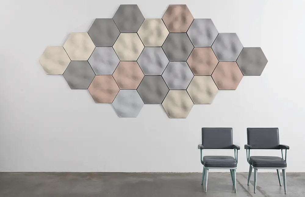 Composición de paneles hexagonales Mogu Wave en gris, crema, rosa y azul claro sobre una pared blanca
