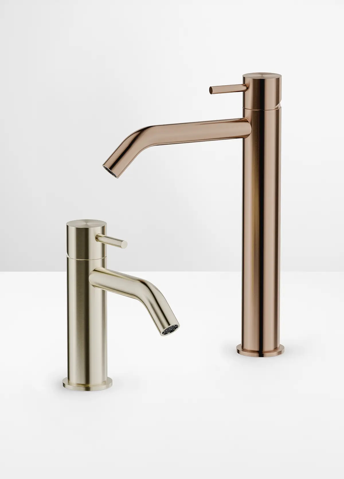 Mezclador de lavabo bajo en tono champán y mezclador alto en tono cobrizo sobre fondo blanco
