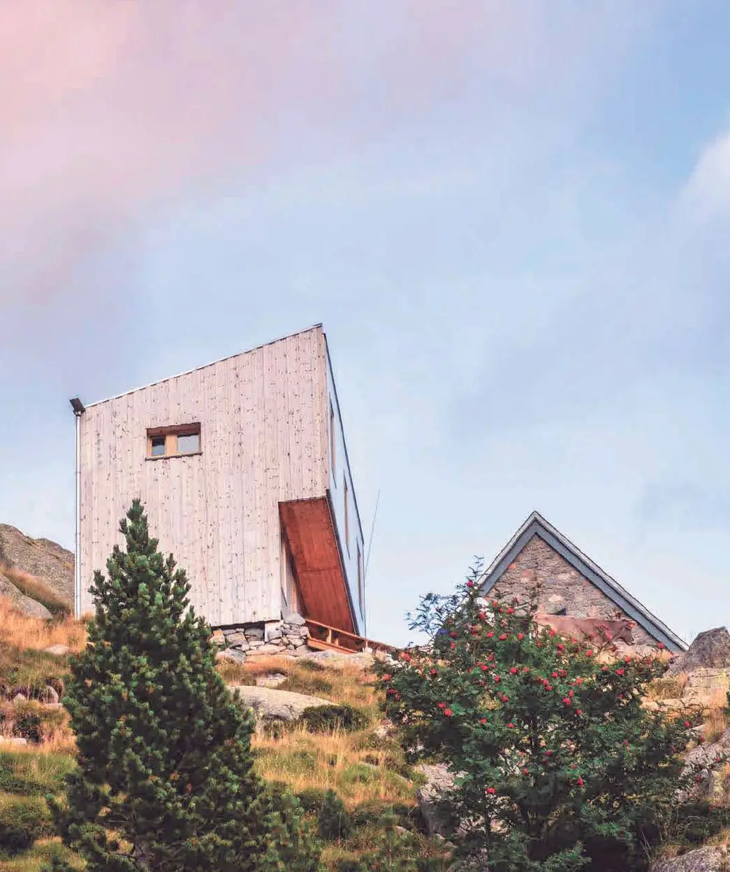 Volumen de madera de la ampliación del refugio Ventosa i Calvell junto al edificio original de piedra