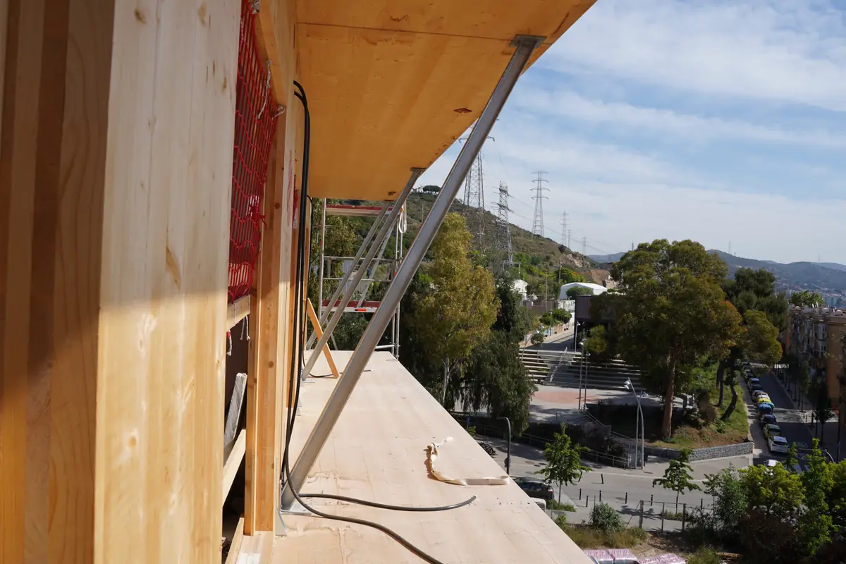 Balcón en obra del edificio Cirerers con paredes y forjado de madera contralaminada y vistas al barrio de Roquetes