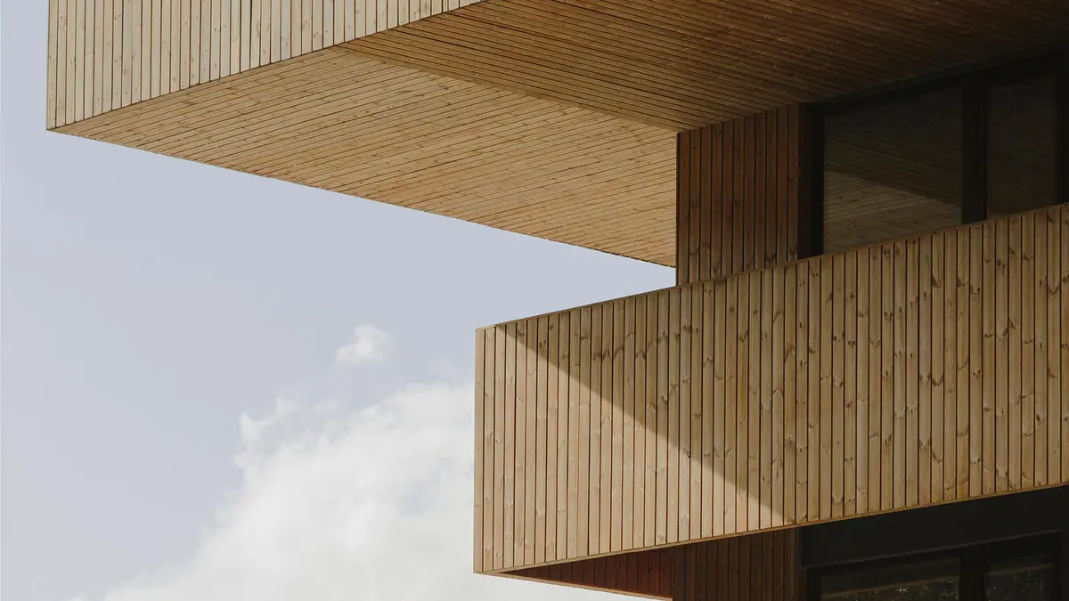Detalle de los voladizos de un edificio revestidos con tablas verticales de madera termotratada