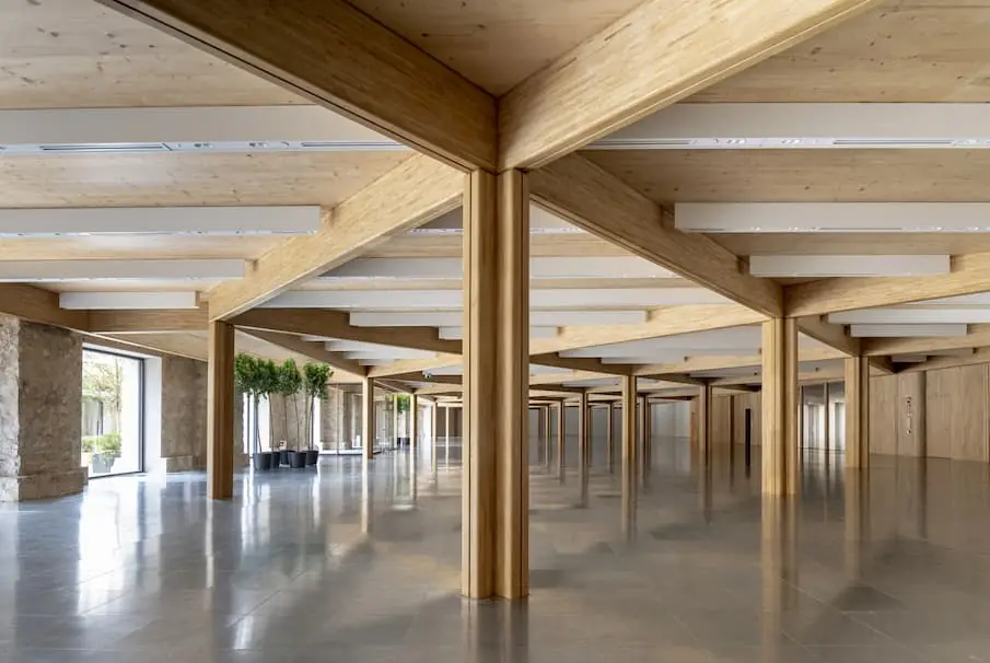 Interior de oficinas de Acciona Ombú con pilares y vigas de madera laminada de castaño.
