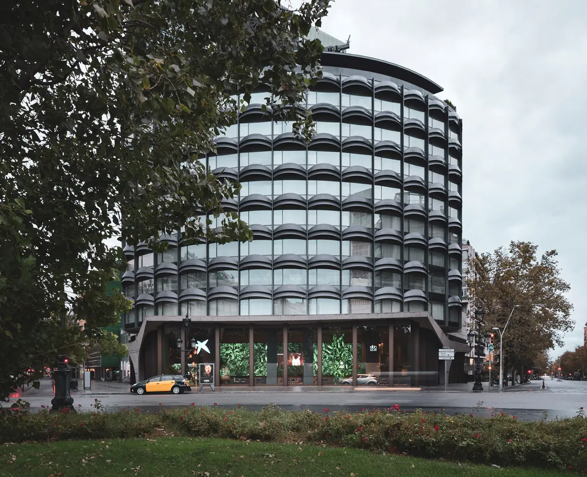 Fachada curva del edificio de la plaza Francesc Macià con la entrada de All in One en planta baja