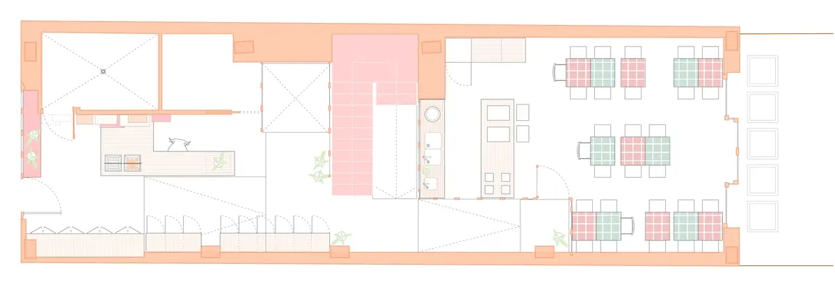 Planta baja del coworking, alargada entre la calle y el patio, con la escalera central y las mesas de la cantina
