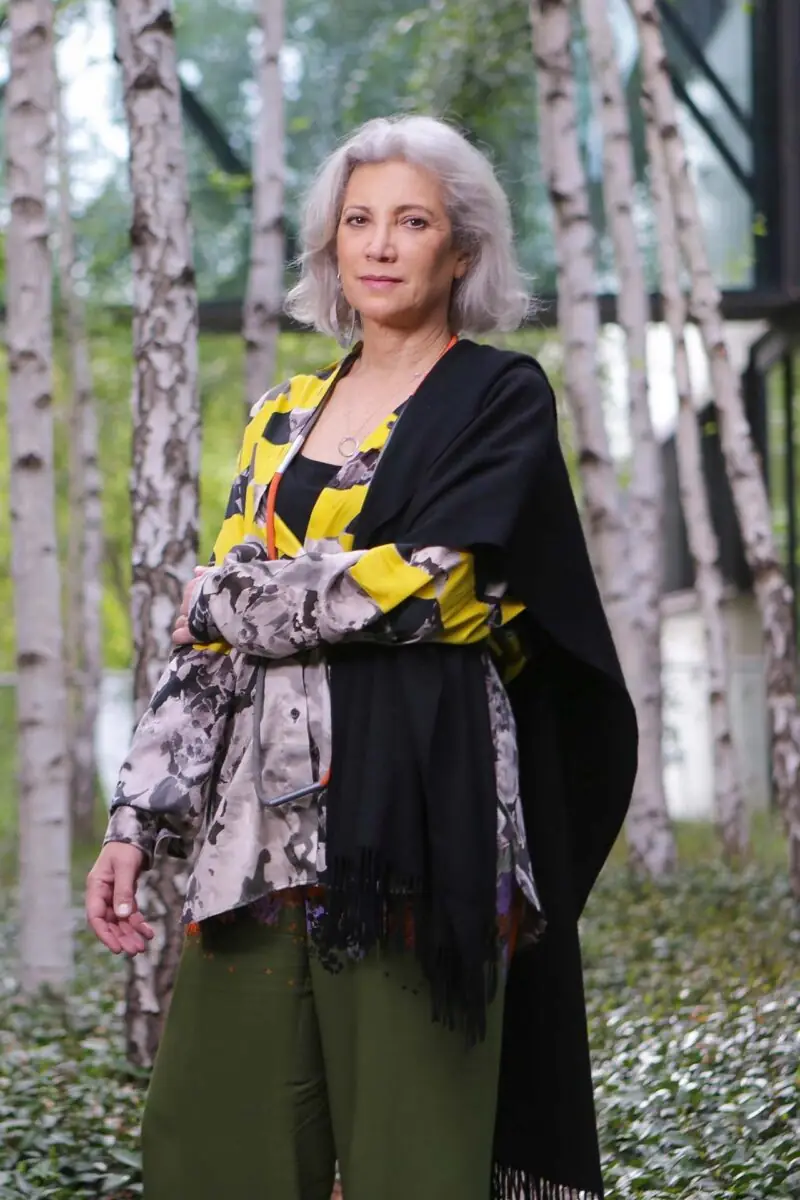 Retrato de la arquitecta Carme Pinós de pie entre abedules