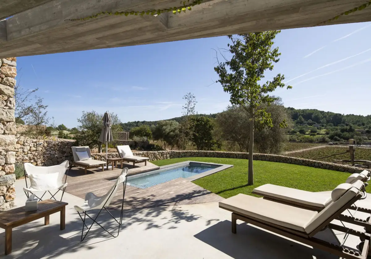 Terraza de una villa con piscina privada, tumbonas y vistas a la viña