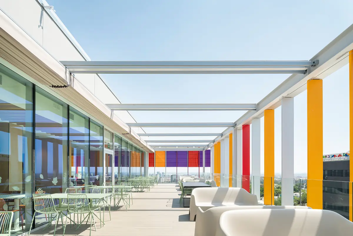 Terraza exterior con pérgola, lamas de colores y mobiliario de exterior