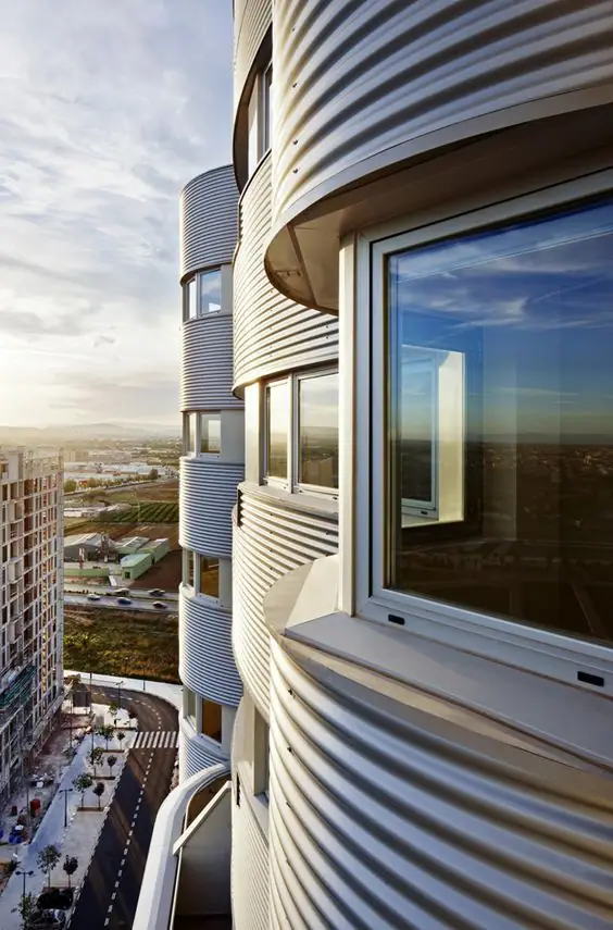 Detalle de la fachada curva de chapa ondulada con ventanas y vistas a la huerta y a Valencia