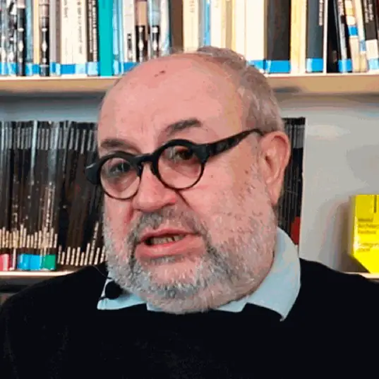 Retrato de Joan Roig durante la entrevista, con gafas redondas, frente a una estantería