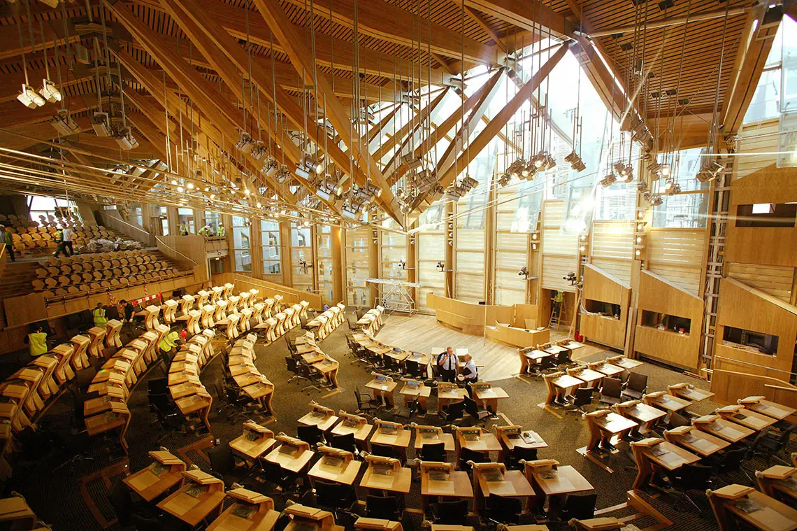Cámara de debates del Parlamento de Escocia, con escaños en hemiciclo y cubierta de vigas de madera
