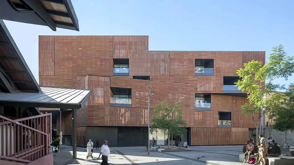 Edificio de viviendas con fachada de lamas de madera frente a la plaza de la Gardunya