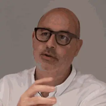 Retrato de Francesc Rifé durante la entrevista, con gafas de pasta oscura y camisa blanca