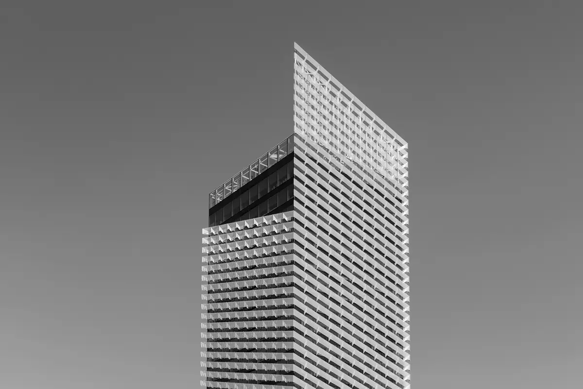 Coronación inclinada de la Torre Puig T1 y su fachada de lamas, en blanco y negro