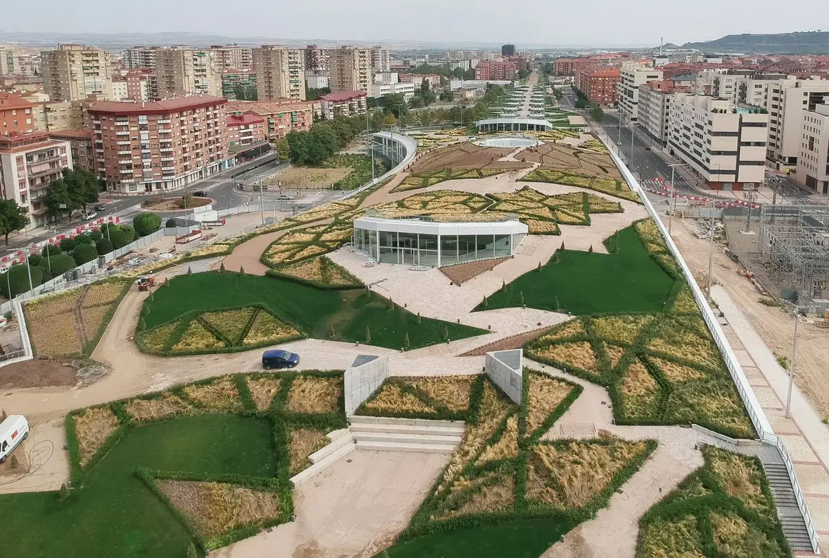 Vista aérea del Parque Felipe VI de Logroño, con caminos, parterres triangulares y pabellones acristalados entre bloques de viviendas