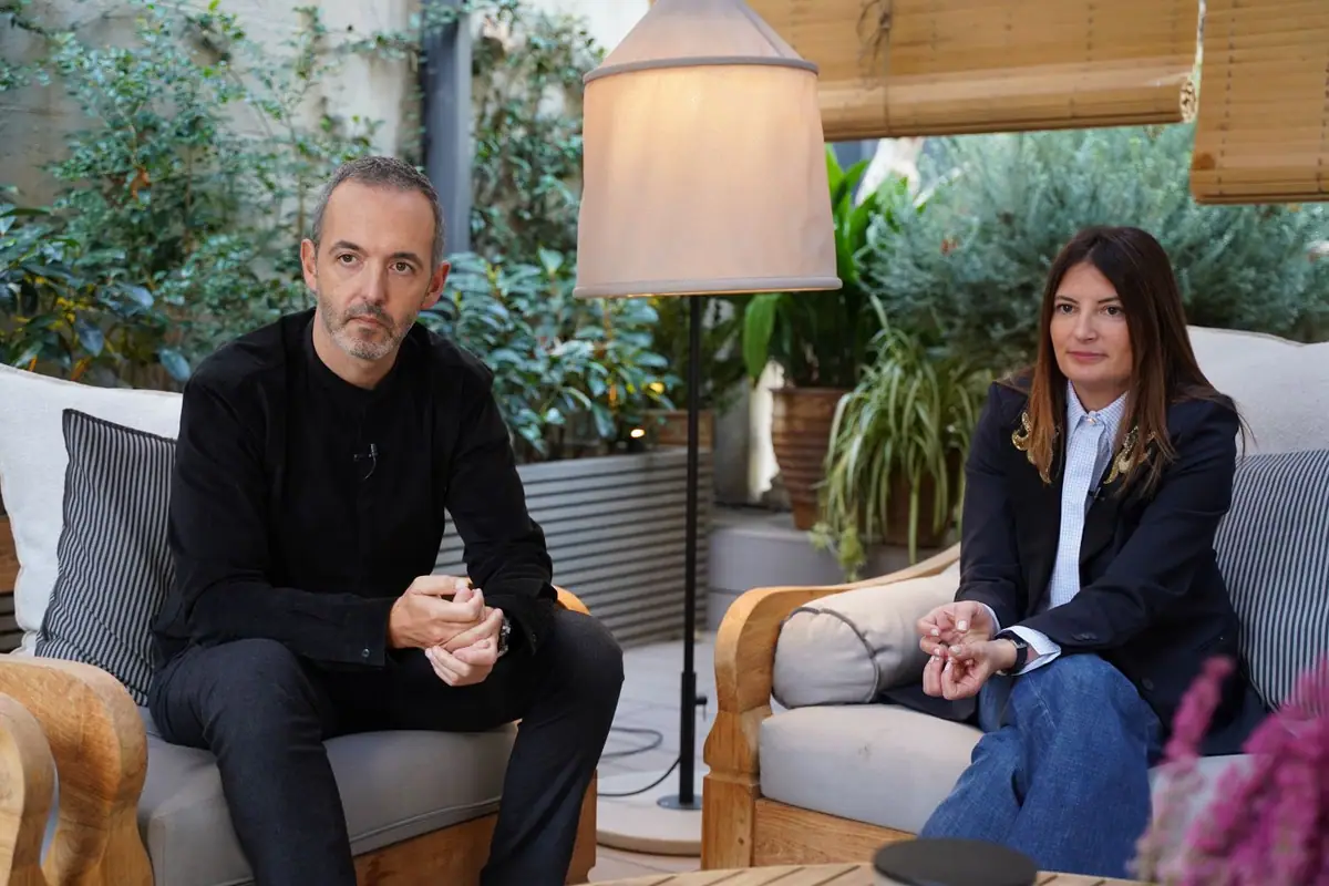 Josep Puigdomènech y Meritxell Ribé sentados en dos butacas de madera durante la entrevista, entre plantas